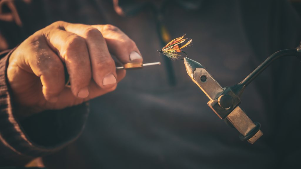 Jumping Rise: Close up of fisherman tying a fly for fishing
